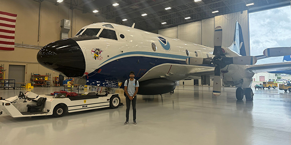 AOS undergraduate Nikhil Trivedi in front of NOAA airplane